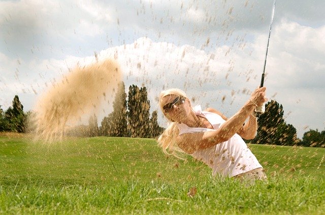Žena v bielom tričku a slnečných okuliaroch hrá golf.jpg