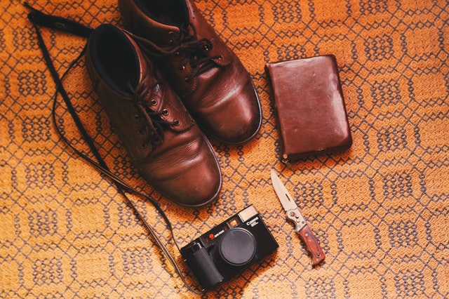 Kožené topánky, nôž a peňaženka na zemi